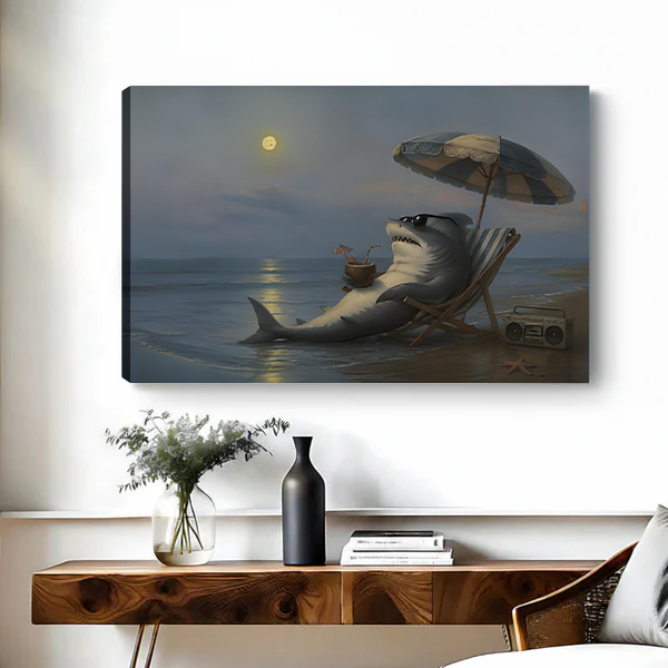 Whimsical moonlit beach shark canvas wall art in a black frame above a console table with plants and books.