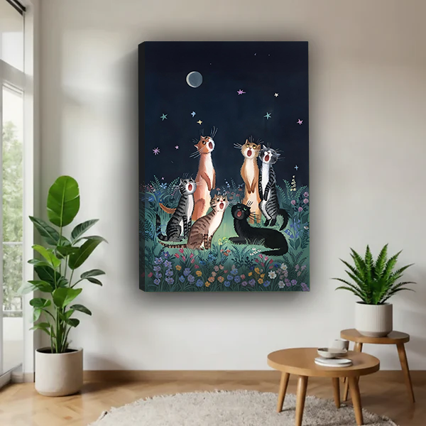 Black framed moonlit cats canvas wall art featuring a starry flower garden above a cream living room sofa.