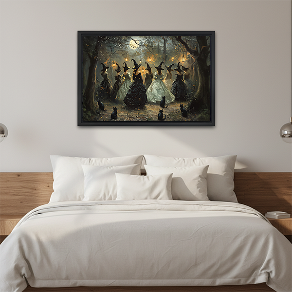 Gothic moonlit forest witches canvas wall art in a black frame above a cream sofa with wooden arms.