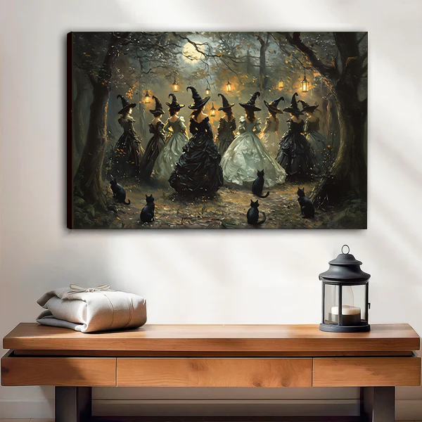 Black framed moonlit forest witches canvas wall art above a wooden console with folded blankets and a lantern.