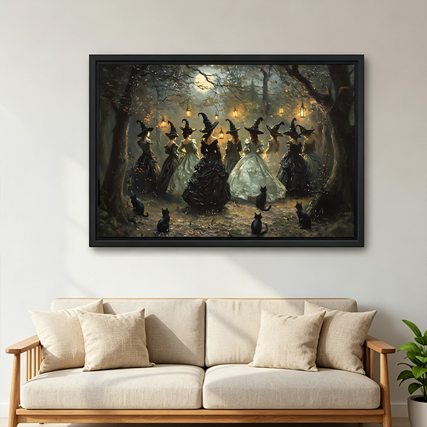 Woman holding framed moonlit forest witches canvas wall art depicting black cats, flowing gowns and glowing woodland lanterns.