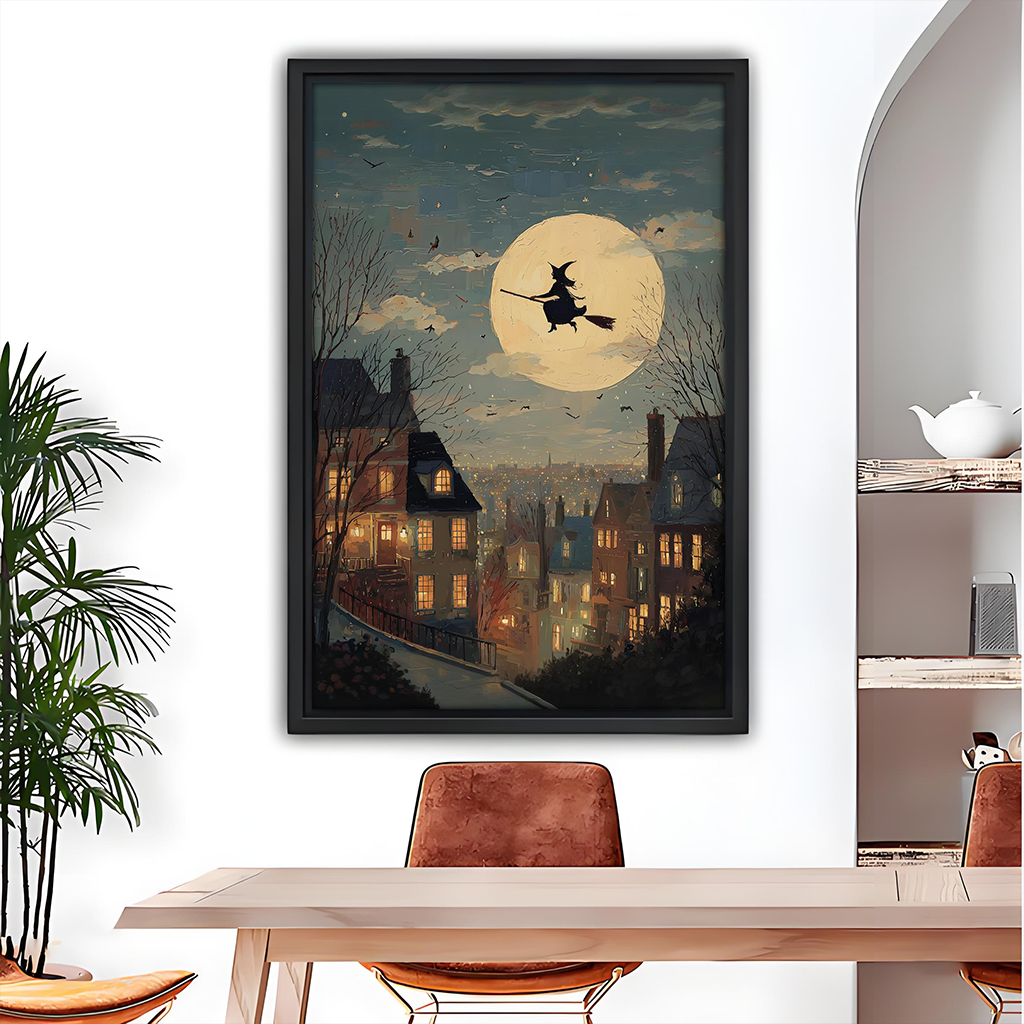 Black-framed moonlit witch canvas wall art featuring a golden full moon and glowing village windows above a dining table.