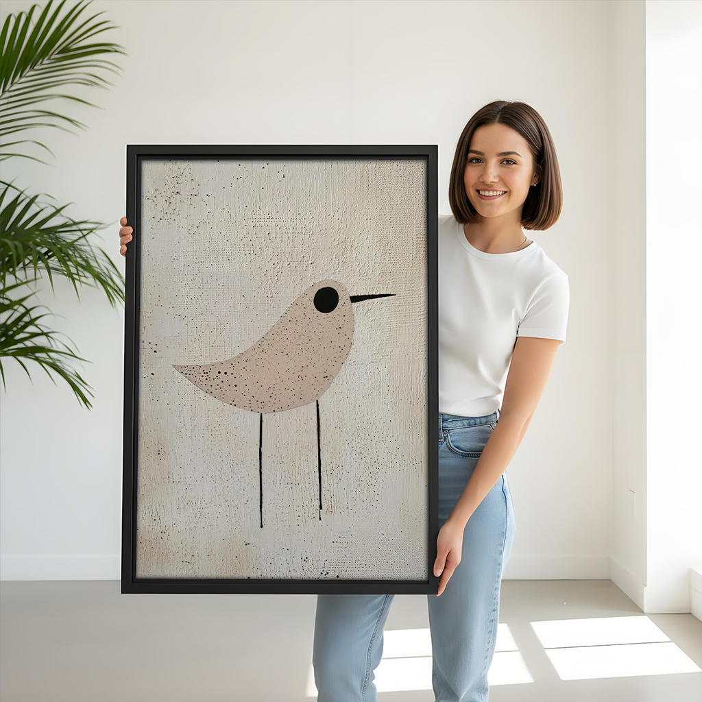 Black-framed minimalist neutral bird canvas wall art above a gray sofa with blue and white pillows.