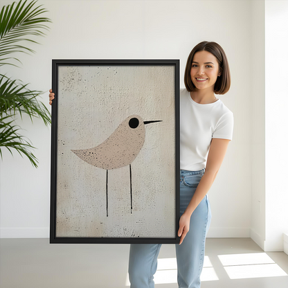 Black-framed minimalist neutral bird canvas wall art above a gray sofa with blue and white pillows.