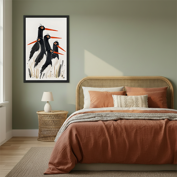 Framed oystercatcher bird watercolor print displayed above a rattan bed headboard in a sage green bedroom