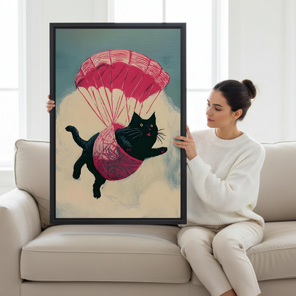 Parachuting black cat canvas wall art in a black frame above a light sofa, adding pink and teal accents.