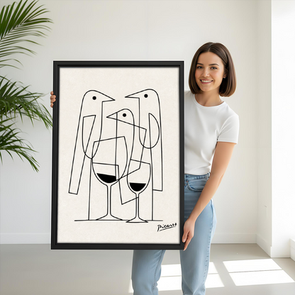 Woman holding large framed Picasso style line art birds and wine wall art print showing size scale in bright white room