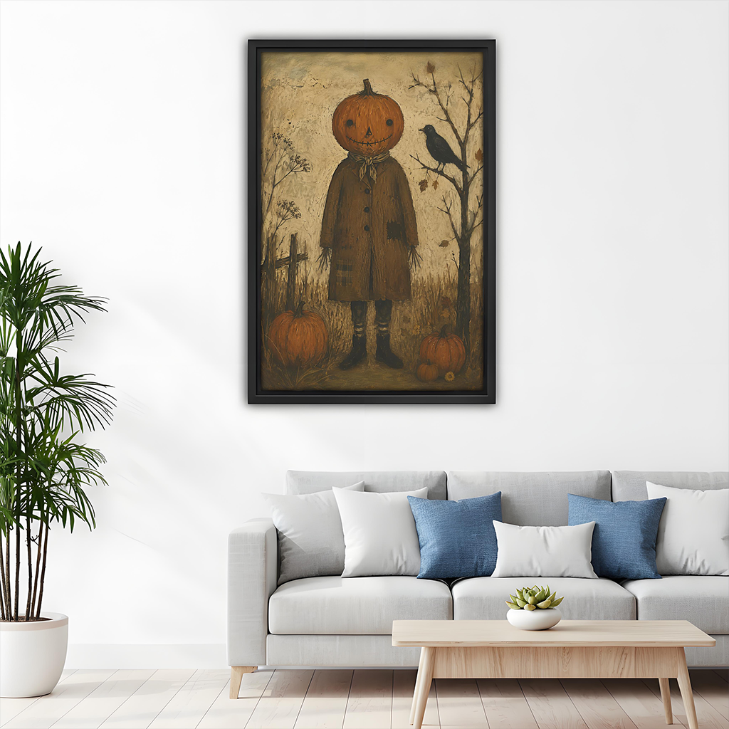 Primitive pumpkin scarecrow canvas wall art in a black frame above a gray sofa with blue cushions.