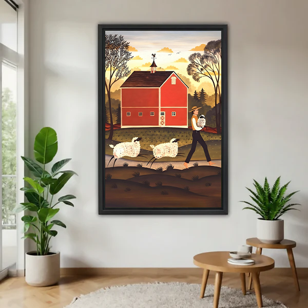 Woman holding framed red barn and sheep canvas wall art showing a country path and golden sky.