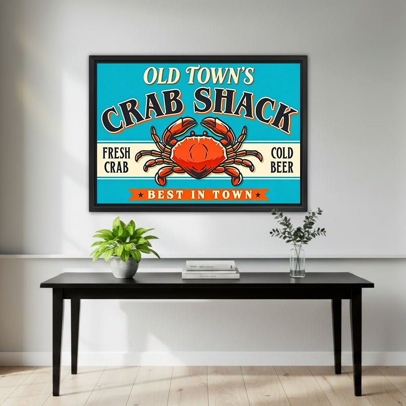 Framed retro crab shack wall art over a black entry table with a green potted plant