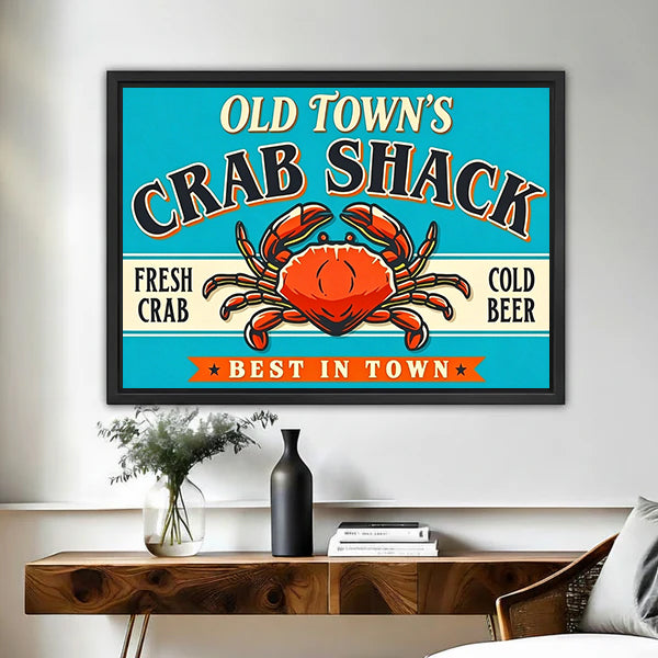 Retro crab shack sign canvas wall art framed above a walnut console with black vase and books