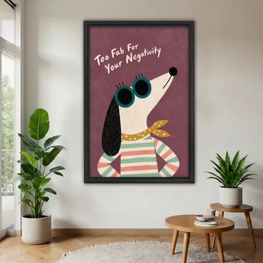 Black-framed retro dog sunglasses canvas wall art with “Too Fab For Your Negativity” lettering beside houseplants.