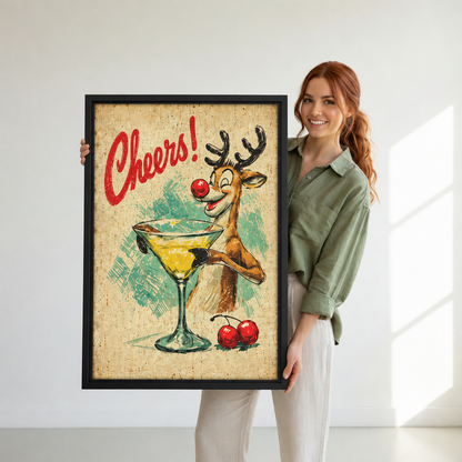 Woman holding black-framed retro reindeer cocktail wall art with a yellow drink, red cherries, and Cheers lettering.