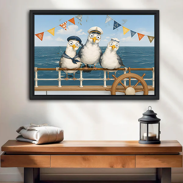 Black-framed sailor seagulls canvas wall art above a wooden console with folded blankets and a black lantern.