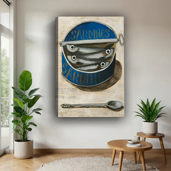 Vintage sardine tin canvas wall art in a black frame beside a rattan bed with terracotta bedding.