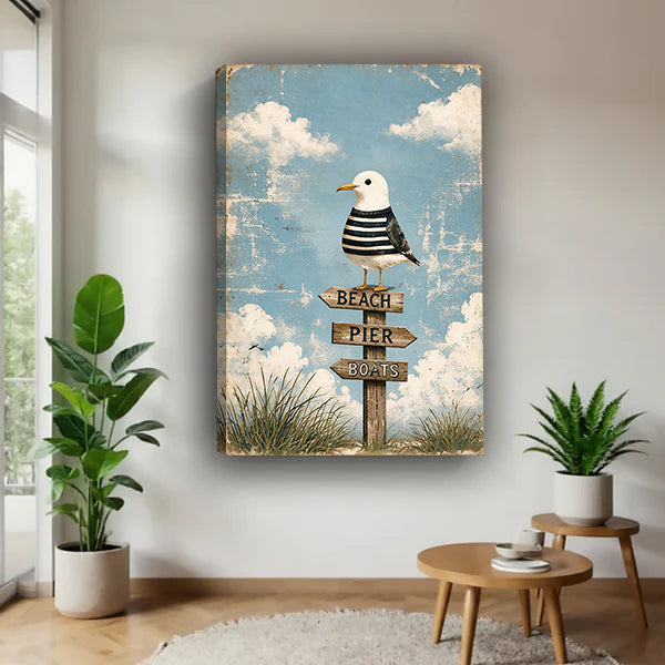 Gallery-wrap coastal seagull signpost canvas wall art in a bright plant-filled corner