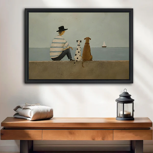 Framed seaside dogs canvas wall art with a seated figure and distant sailboat above a bed with white bedding.