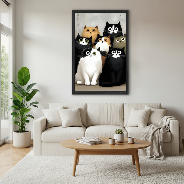 Woman holding black-framed seven cats canvas wall art featuring wide-eyed black, white, ginger, calico, and gray cats.