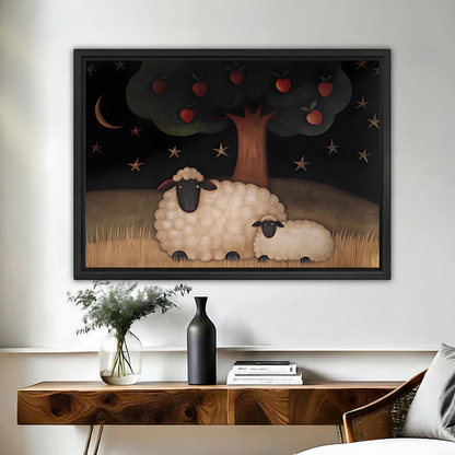 Woman holding black-framed sheep and apple tree canvas wall art featuring a sheep and lamb beneath a starry sky.