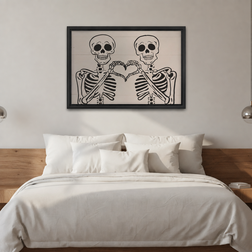 Two smiling skeletons forming a bone heart on white shiplap background framed canvas above white linen bed with wood headboard and silver wall lamps