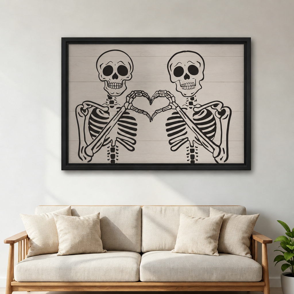 Two skeletons making a heart shape with their bone hands on shiplap background framed canvas above cream linen sofa with white cushions and green plant