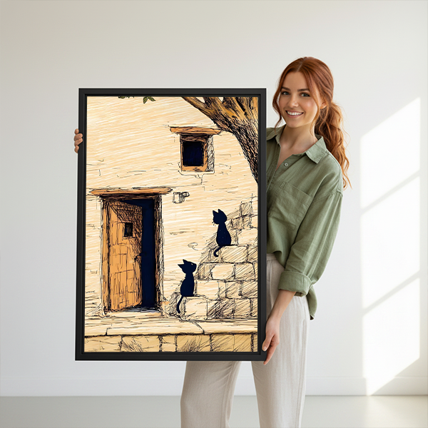 Smiling woman holding sketch black cats stone cottage framed art print showing size reference on white background