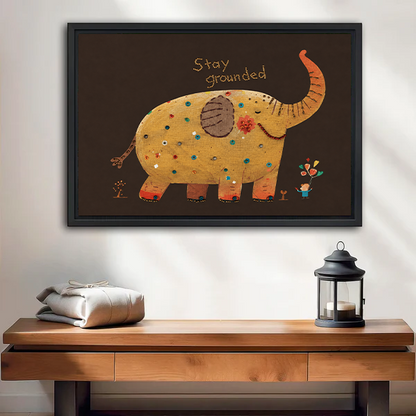 Woman holding framed Stay Grounded elephant canvas wall art featuring a golden elephant with colorful folk art details.