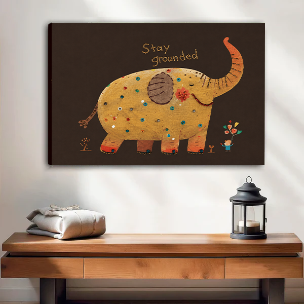 Stay Grounded elephant canvas wall art without an outer frame above a wooden console beside a black lantern.
