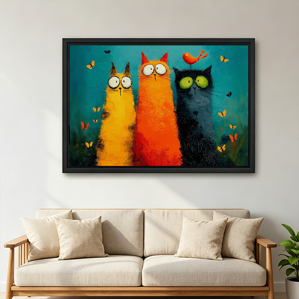 Framed whimsical three cats canvas wall art with butterflies and a teal background above a wooden console.