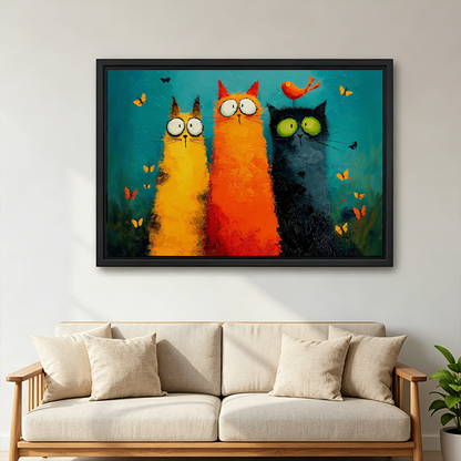 Framed whimsical three cats canvas wall art with butterflies and a teal background above a wooden console.