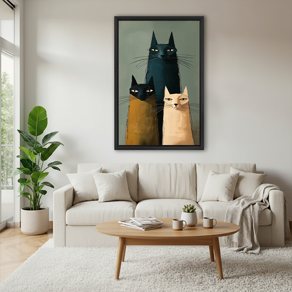 Framed three cats canvas wall art in a modern folk style displayed above a cream sofa in a bright living room.