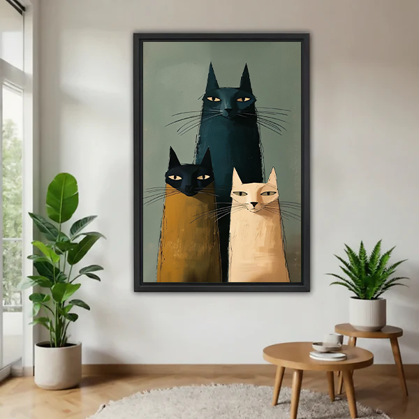 Black-framed three cats canvas wall art in teal, mustard and cream displayed between potted plants above wooden tables.