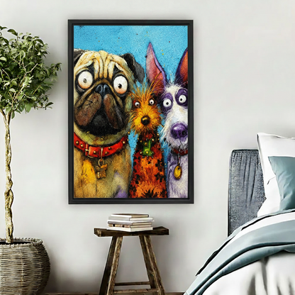 Black framed expressive cartoon dog trio art print hung in a cozy bedroom beside a rattan basket plant and wooden stool, featuring a startled pug, fluffy orange terrier, and wide-eyed grey schnauzer on a bold blue background