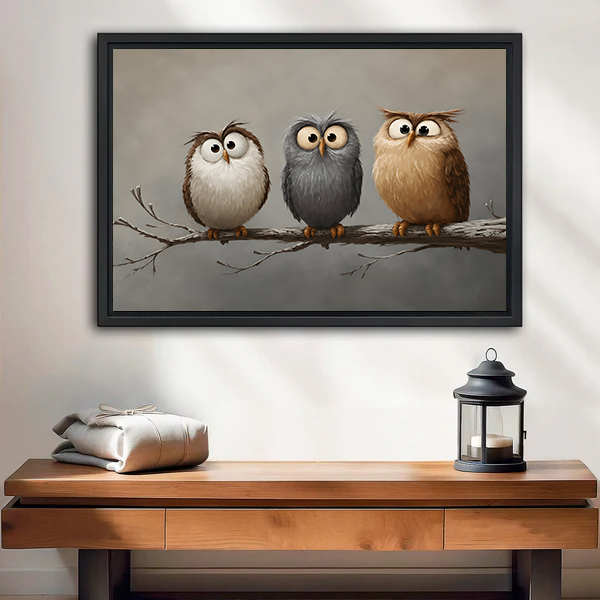 Framed canvas wall art featuring three cute owls perched on a branch, displayed above an entryway console table