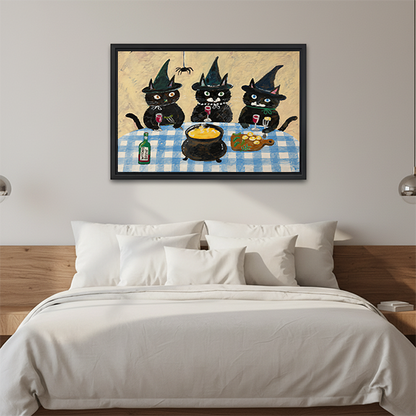 Woman holding framed three witch cats canvas wall art depicting black cats in witch hats around a cauldron.