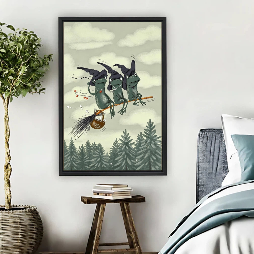 Three witch frogs flying on broomstick over pine forest framed canvas print hung on bedroom wall