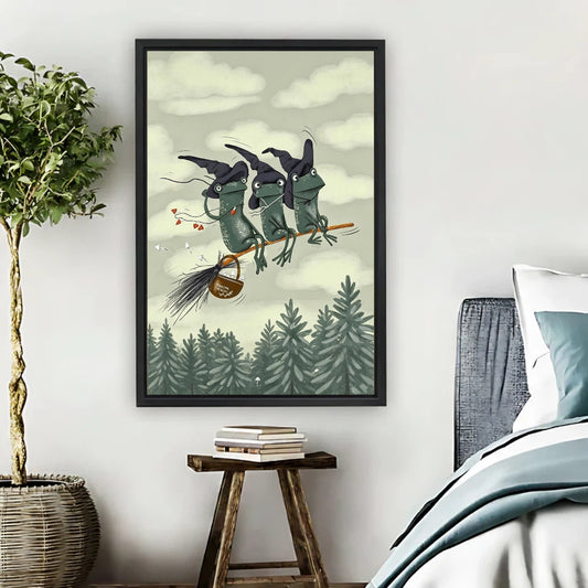 Three witch frogs flying on broomstick over pine forest framed canvas print hung on bedroom wall
