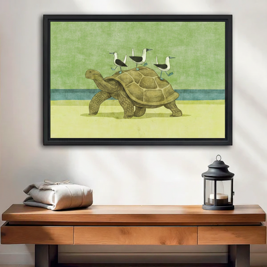 Framed wall art print of a tortoise with seagulls on its back, displayed above a wooden console table in a modern entryway
