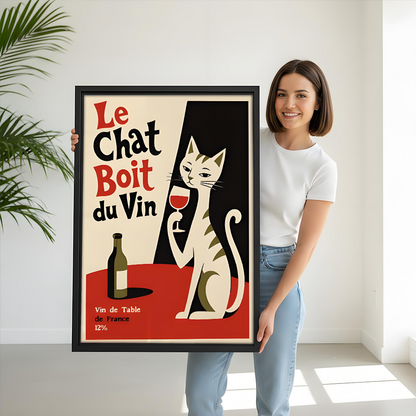 Framed vintage French cat wine canvas wall art above a sofa with a potted plant.