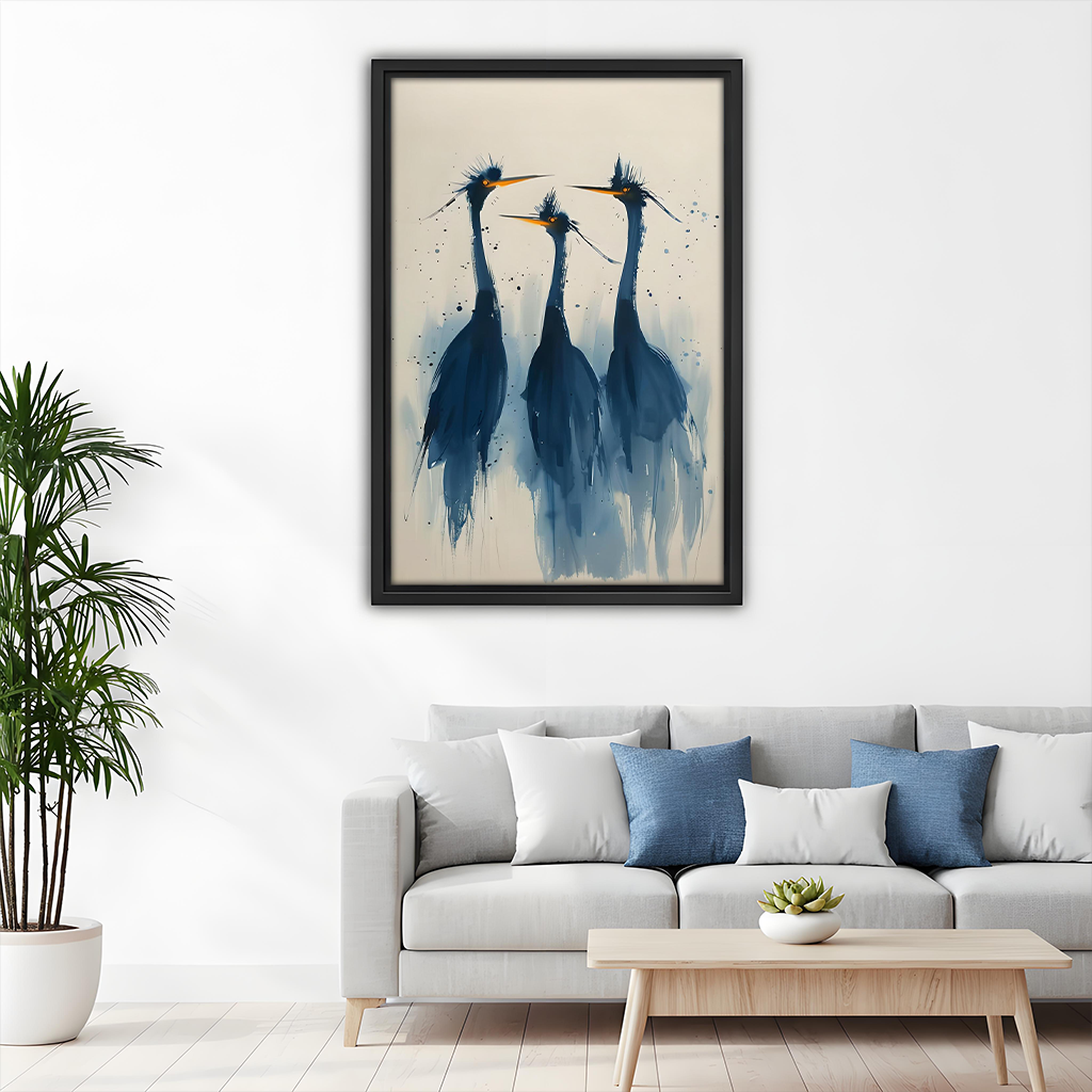 Watercolor blue herons trio framed canvas wall art above a white sofa with blue cushions in a bright minimalist living room with palm plant
