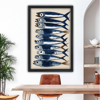 Watercolor sardine fish stack canvas wall art in black frame hanging above wooden dining table in bright airy room