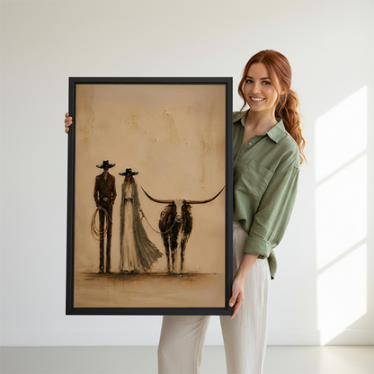 Framed western couple and longhorn canvas wall art hangs on a wall between indoor plants.
