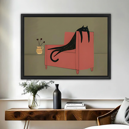 Woman holding framed whimsical black cat canvas wall art featuring a lounging cat on a coral armchair.
