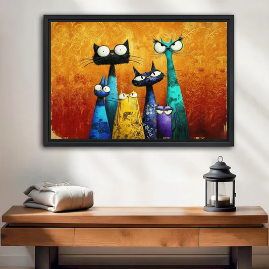 Framed wall art print of six whimsical colorful cats with expressive eyes on a golden orange textured background, displayed above a wooden console table