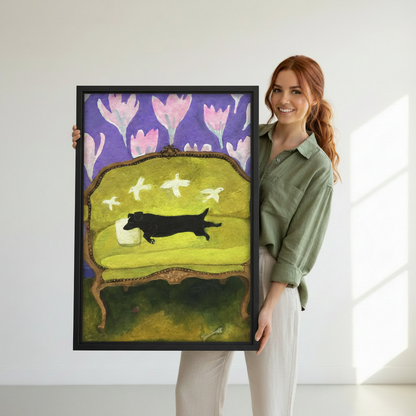 Smiling woman holding large whimsical dachshund folk art floral vintage wall art print with black frame, white background
