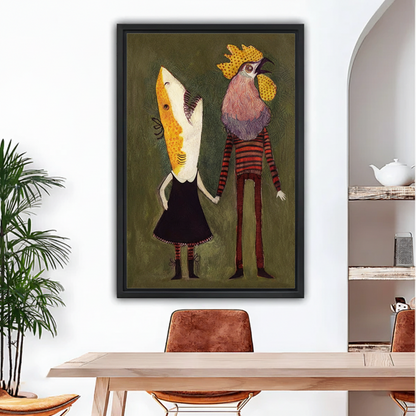 Whimsical folk art couple canvas wall art in black frame hanging on white wall above wooden dining table with plant