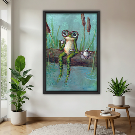 Whimsical frog wearing red glasses sitting on log with tea cup and teapot by pond framed wall art on white wall, quirky expressionist animal canvas for living room