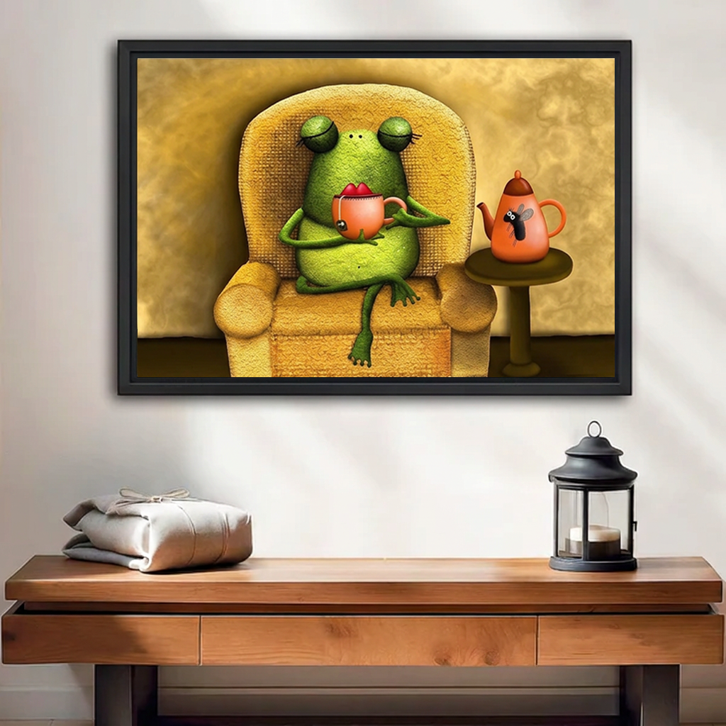Black-framed whimsical frog tea time wall art above a wooden bench with folded blankets and a candle lantern
