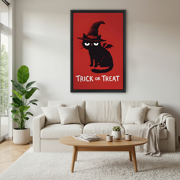Halloween cat canvas wall art in a black frame hangs above a pale sofa, showing a witch hat and Trick or Treat.