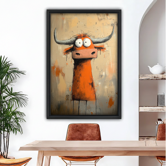 Framed whimsical longhorn bull canvas print in black float frame hung above dining room table